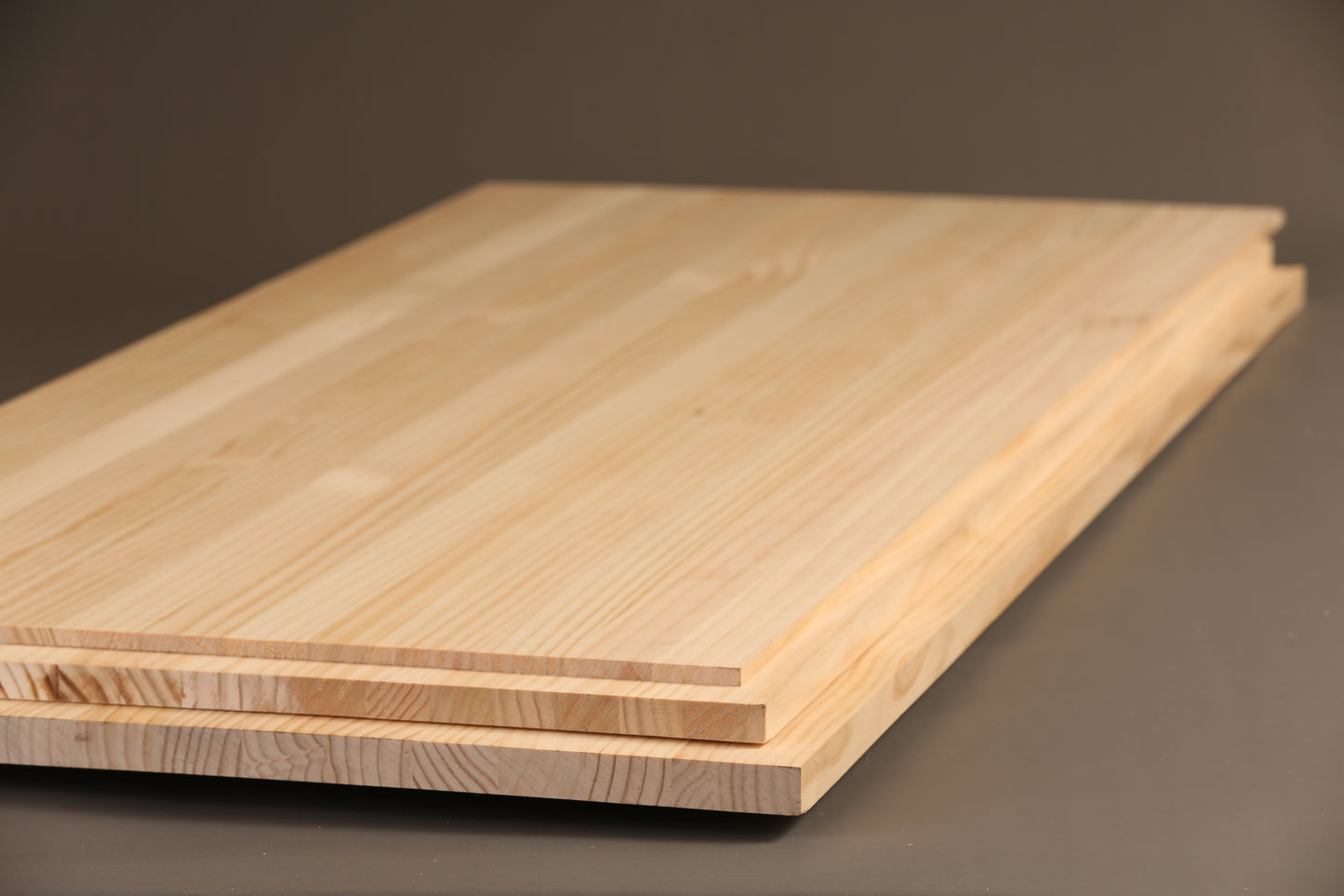 Two wooden boards stacked on a dark surface