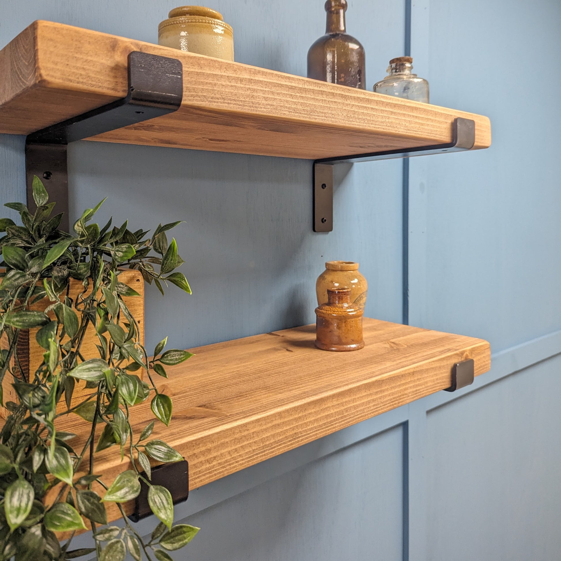 Light Oak Wooden shelves with metal brackets against a blue wall
