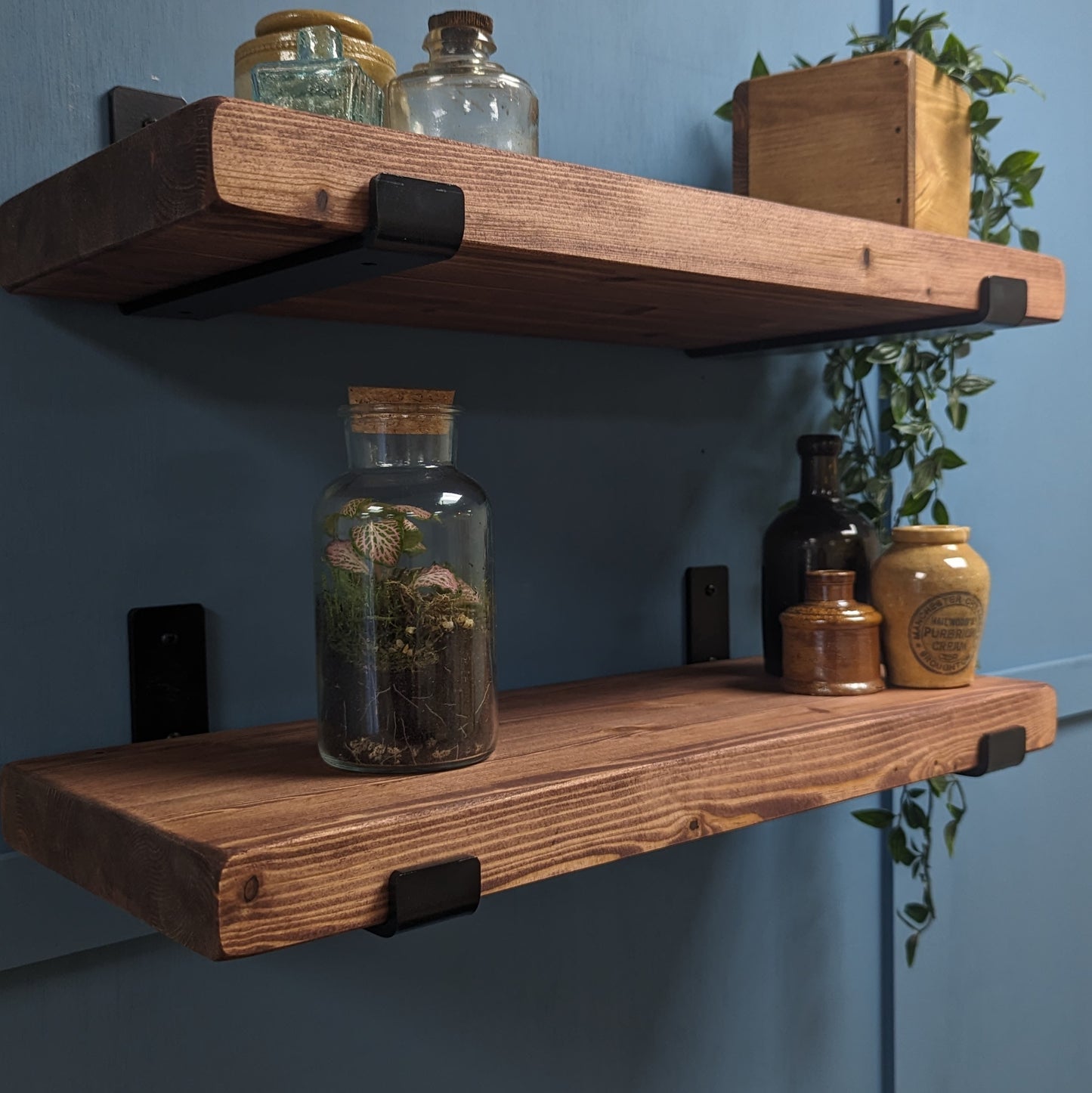 Walnut Wooden shelves with decorative jars against a blue wall